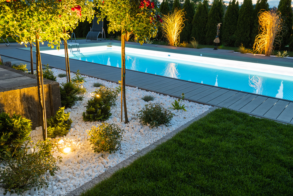 Outdoor pool and landscape lighting installation creating elegant backyard illumination for a residential property.